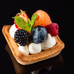 Fresh Fruit Tart with berries isolated on black background