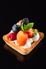 Fresh Fruit Tart with berries isolated on black background