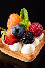 Fresh Fruit Tart with berries isolated on black background