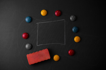 Fototapeta na wymiar Round Flat shape stones with one eraser stick to old chalk black board