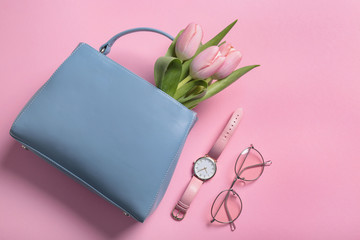 Flat lay composition with stylish woman's handbag and spring flowers on color background - obrazy, fototapety, plakaty