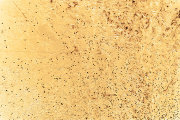 Vintage yellow background. Rough painted wall of aspen gold color. Imperfect plane of golden colored. Uneven old decorative toned backdrop of yellow tint. Texture of gold hue. Ornamental stony surface