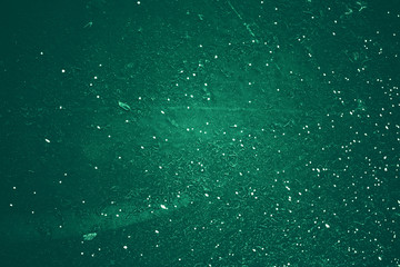 Vintage green background. Rough painted wall of emerald color. Imperfect plane of virid colored. Uneven old decorative toned backdrop of green tint. Texture of emerald hue. Ornamental stony surface.