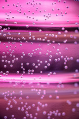 Macro shot of backlit water and air bubbles over colored background. Tiny air bubbles inside water base.