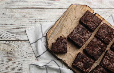 Flat lay composition with fresh brownies and space for text on wooden background. Delicious...