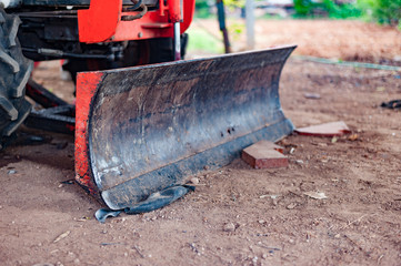 The grounding blade attached to the tractor is used to smooth the area.