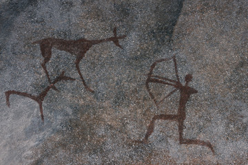 scene of ancient hunting painted on the wall of the cave. history of antiquities, archaeology.