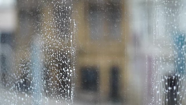 Cleaning windows vertically with a window sweeper squeegee and gloves close up