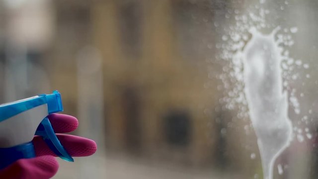 Spraying on windows with a window cleaning solution close up
