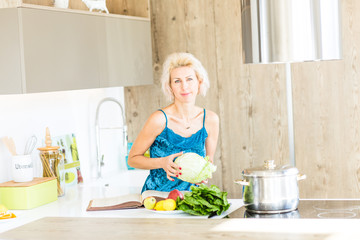 young blonde woman cooking in modern kitchen