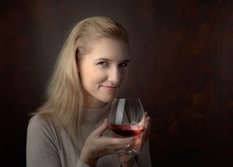 Portrait of a beautiful woman with glass of brandy.