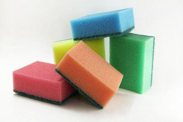 Foam sponges of different colors on a white background. Devices for washing dishes and cleaning the house.