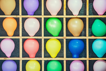 Children's shooting range in the amusement city park. Multicolored balloons are targets in a...