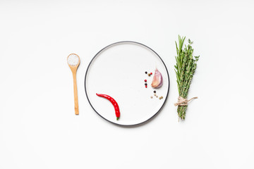 Empty plate with greens herbs and spices around