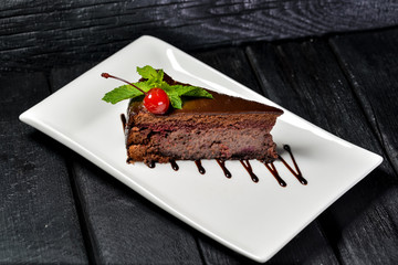 piece of chocolate cake on a plate with fork and knife