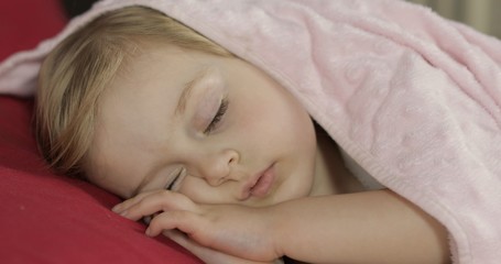 Cute baby sleeping on the bed at home. Little girl sleeping in morning light