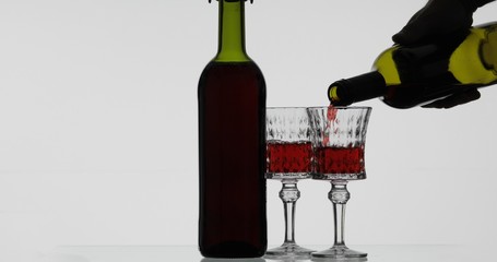 Rose wine. Red wine pour in wine glass over white background