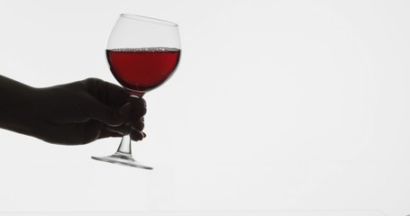 Rose wine. Woman hold red wine in wine glass over white background