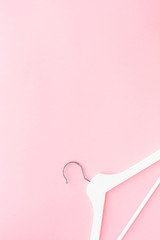 White hangers on pastel pink background