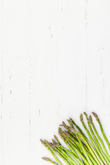 Fresh green asparagus on white wooden background