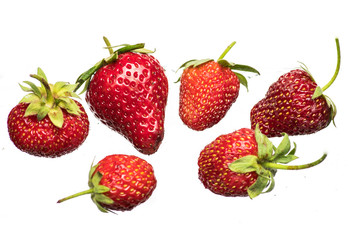 Ripe strawberries on a light background with splashing water close up