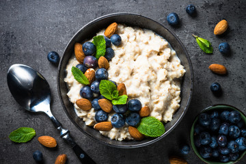 Oatmeal porridge with fresh berries and nuts top view. 