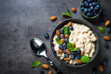 Oatmeal porridge with fresh berries and nuts top view. 