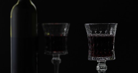 Rose wine. Red wine in wine glass over black background. Silhouette