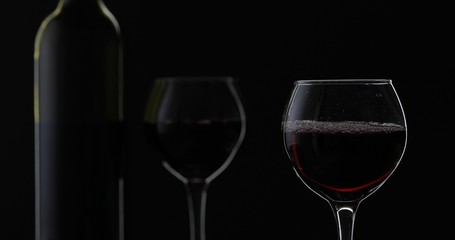 Rose wine. Red wine in wine glass over black background. Silhouette