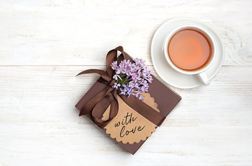 flower, gift box and cup of tea on white background. concept birthday, gift for dad, men, brutal style. holiday spring greeting background. top view, copy space