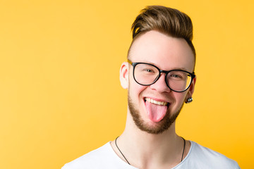 Portrait of positive, cheerful young guy with trendy comb over haircut. Funny emotional man...