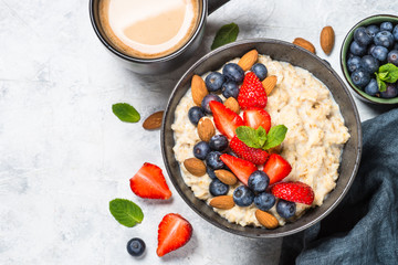Oatmeal porridge with fresh berries and nuts top view. 
