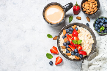 Oatmeal porridge with fresh berries and nuts top view. 