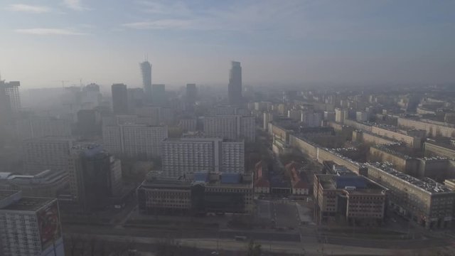 Aerial sunrise view of the morning sun in the fog over the Warsaw City. Commercial skyscrapers in the center of the metropolis. Taken from a drone in 4K