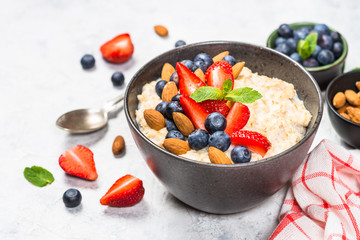 Oatmeal porridge with fresh berries and nuts. 