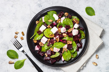 Fresh salad from spinach, beet and feta cheese with walnut.