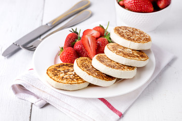 Homemade Cottage Cheese Pancakes with Ripe Strawberry on White Plate on White Wooden Background Tasty Healthy Breakfast or Lunch Horizontal
