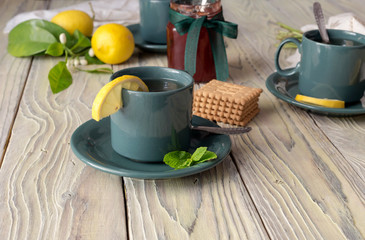 Mint tea in cups and lemons on a wooden table close-up