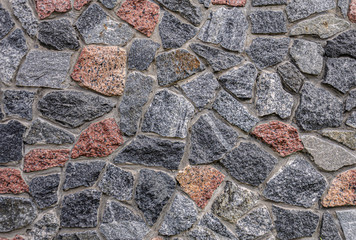 Powerful reliable wall (fence) from multi-colored - gray and red granite.