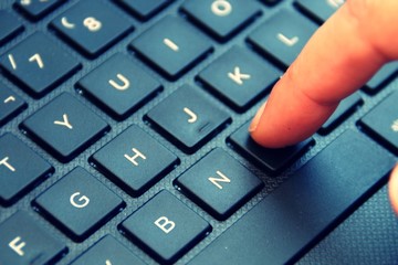 Using the laptop. Girl finger typing.