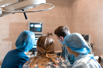 A team of pet surgeons monitors sensors on screens at the time of surgery
