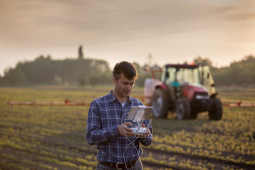 Farmer driving drone above field