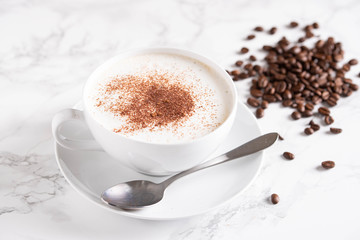 cappuccino with coffee beans on marble background