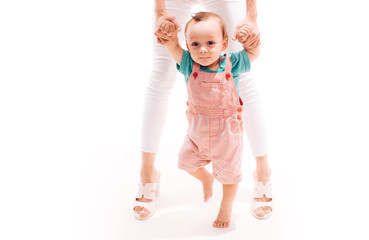 Helping baby learn to walk. Small child walking with help, motor skills. Little boy child develop gross motor activity. Toddler stage of development. Adorable small toddler. Little baby learn to walk