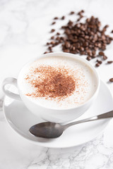 cappuccino with coffee beans on marble background