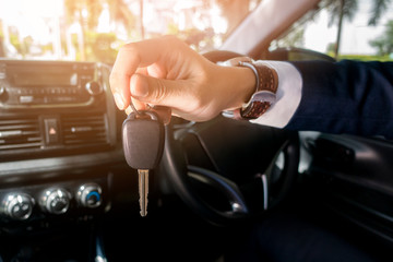 Business man  is holding key car in the car