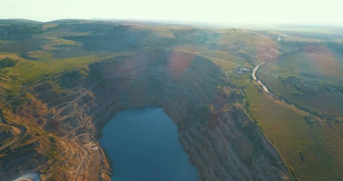 Aerial view of opencast mining quarry with lots of machinery at work - view from above. 