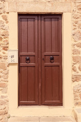The background old beige stony wall with retro door