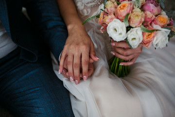 Bridal bouquet in the hands of the newlyweds