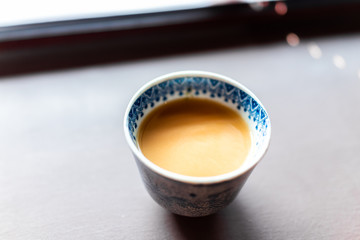 Traditional japanese cup with amazake sweet sake fermented healthy drink on table closeup made with healthy brown rice